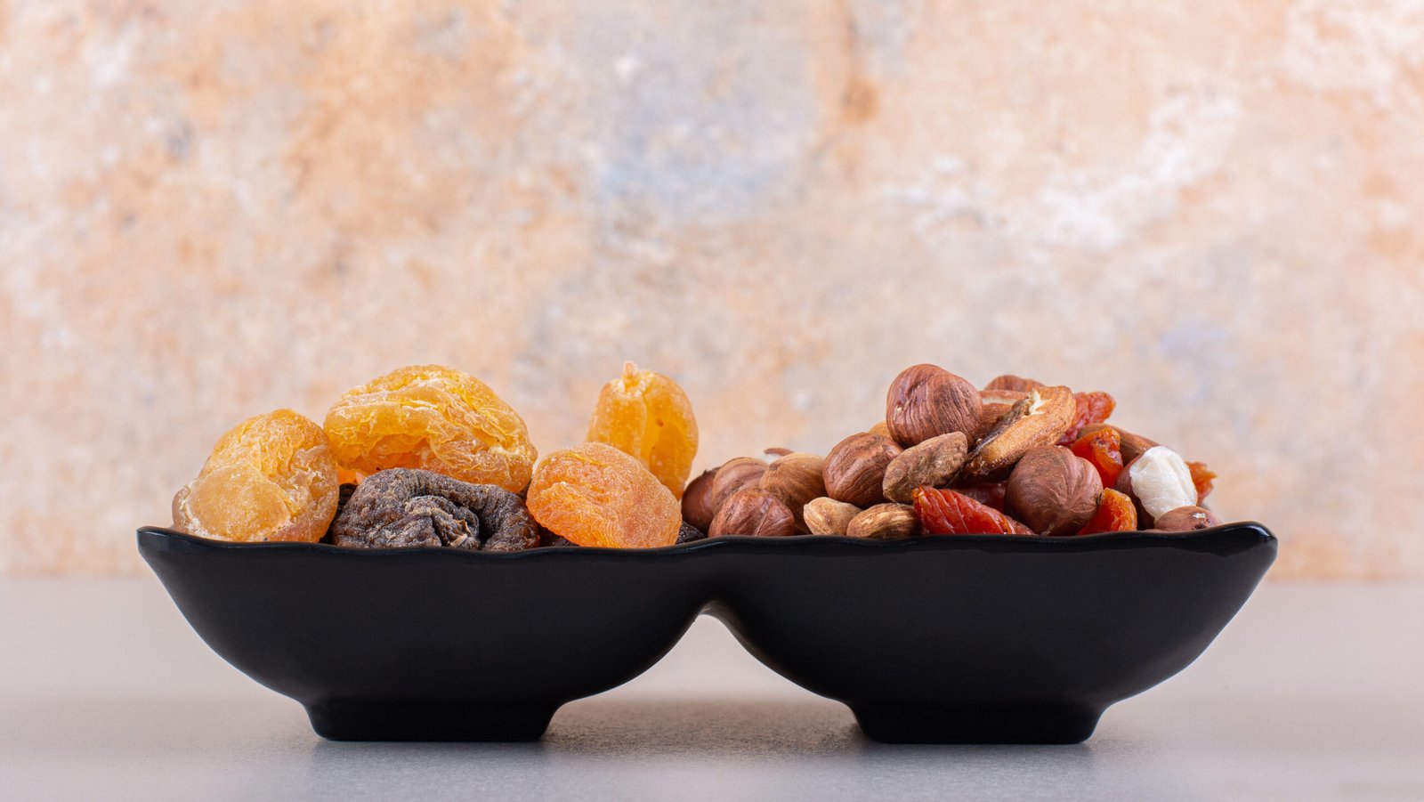 dark plate of various organic nuts on white background